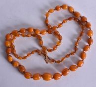 AN AMBER NECKLACE. 40 grams. 88 cm long, largest bead 1.75 cm wide.