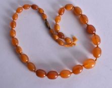 AN AMBER NECKLACE. 33 grams. 48 cm long, largest bead 2 cm wide.