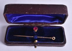 A 15CT GOLD AND RUBY PIN. 2.7 grams. 5.5 cm long.