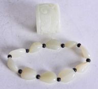 A JADE ARCHERS RING AND A JADE BEAD EXPANDING BRACELET. Ring 3.5 cm x 3 cm (2)