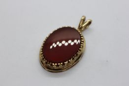 A 9CT GOLD MOUNTED CARNELIAN PENDANT APPROX 20MM X 15MM.