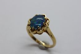 AN 18CT YELLOW GOLD OVAL OPAL SET RING, CLAW SET IN LOBED MOUNT.