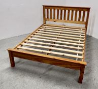 A HONEY PINE KING SIZE BED FRAME.