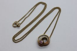 A 9CT YELLOW GOLD PENDANT NECKLACE SET WITH AMETHYST AND THREE SMALL GRADUATED DIAMONDS.