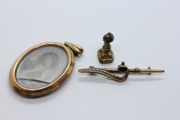 A VINTAGE GILT PHOTO LOCKET AND A HARDSTONE SEAL, YELLOW METAL STONE SET BROOCH.