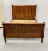 A SOLID STAINED PINE KING SIZE SLEIGH BED (MARKED).