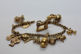 A 9CT YELLOW GOLD CHARM BRACELET WITH FOURTEEN CHARMS (ONE CHARM DETACHED).