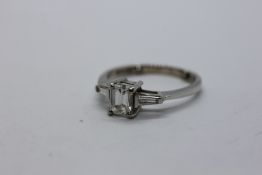 AN 18CT WHITE GOLD ENGAGEMENT RING SET WITH EMERALD CUT DIAMOND WITH DIAMOND TAPERED BAGUETTE