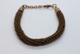A GEORGIAN MOURNING BRACELET WITH ORNATE GILT MOUNTS AND CLASP.