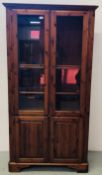 A DUCAL HONEY PINE GLAZED TWO DOOR CABINET WITH CUPBOARD BASE, W 99CM X D 31CM X H 189CM.