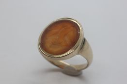 A VINTAGE YELLOW METAL OVAL HARDSTONE INTAGLIO SIGNET RING,