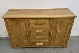 A MODERN SOLID LIGHT OAK SIDEBOARD, THE THREE CENTRAL DRAWERS FLANKED BY CUPBOARDS,