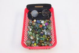A BASKET OF ASSORTED VINTAGE MARBLES AND A PAIR OF CASED VINTAGE SPECTACLES.