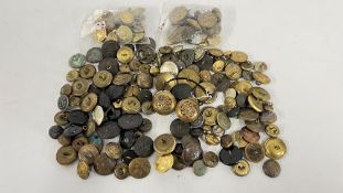 A TUB CONTAINING AN ASSORTMENT OF VINTAGE BUTTONS TO INCLUDE MILITARY AND NAVAL EXAMPLES.