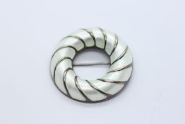 A DESIGNER DAVID ANDERSEN NORWEGIAN SILVER AND WHITE ENAMEL CIRCULAR BROOCH.