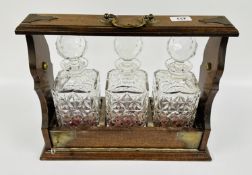 A MODERN MAHOGANY THREE BOTTLE TANTALUS AND KEY.