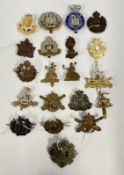 A TUB CONTAINING AN ASSORTMENT OF VINTAGE CAP BADGES TO INCLUDE LOCAL AND MILITARY EXAMPLES.