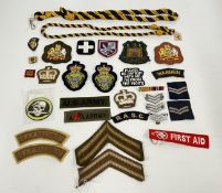 A TUB CONTAINING A GROUP OF VINTAGE CLOTH BADGES TO INCLUDE RAF AND COMMEMORATIVE EXAMPLES.