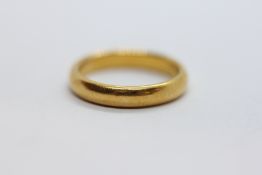 A 22CT GOLD WEDDING BAND, SIZE P/Q.