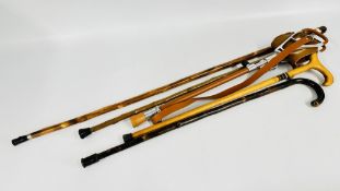 GROUP OF 5 WALKING STICKS TO INCLUDE A SHOOTING STICK PLUS 4 OTHER WOODEN RUSTIC WALKING STICKS.