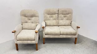 A BEIGE UPHOLSTERED FIRESIDE CHAIR AND A MATCHING TWO SEATER SOFA.
