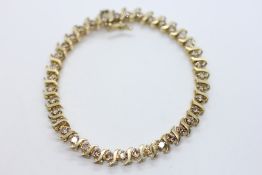 AN ELABORATE SMOKEY DIAMOND TENNIS BRACELET, THE CLASP STAMPED 10K, L 19CM.