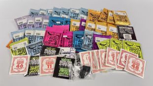 A BOX CONTAINING A LARGE QUANTITY OF SEALED PACKETS OF GUITAR STRINGS.