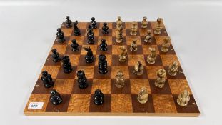 A POLISHED HARD STONE CHESS SET AND WOODEN BOARD.