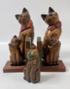 A FAMILY OF 3 CARVED WOODEN CAT SCULPTURE + A PAIR OF SIMILAR BOOKENDS.