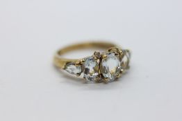 A MODERN 9CT GOLD AND AQUAMARINE GRADUATED FIVE STONE RING IN A FITTED PRESENTATION BOX.