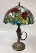 A DECORATIVE TIFFANY STYLE LAMP AND SHADE FEATURING A LEADED GLASS DESIGN WITH A FLORAL PATTERN,