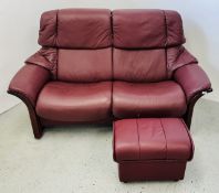 A GOOD QUALITY STRESSLESS TWO SEAT RECLINER SOFA IN BURGUNDY LEATHER WITH FOOTSTOOL.
