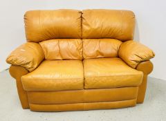 A MODERN LIGHT TAN LEATHER UPHOLSTERED TWO SEATER SOFA.