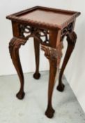 A CARVED REPRODUCTION OCCASIONAL TABLE ON BALL AND CLAW FEET.