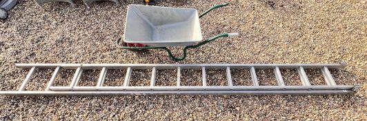 A GARDEN WHEELBARROW ALONG WITH AN ALUMINIUM DOUBLE EXTENSION LADDER.