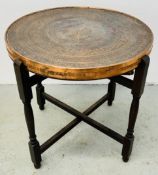A MIDDLE EASTERN PERSIAN STYLE COPPER ENGRAVED MULTI PURPOSE TRAY / GAMES TABLE ON A FOLDING WOODEN