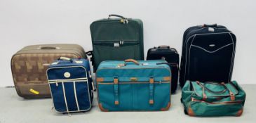A GROUP OF ASSORTED LUGGAGE CASES + A HOLDALL CONTAINING VARIOUS WALLPAPER ROLLS.