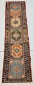 A TURKISH STYLE RUNNER FEATURING A GEOMETRIC PATTERN WITH A CENTRAL DIAMOND DESIGN, L 180 X W 78CM.