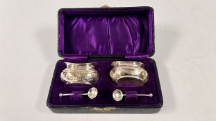 A PAIR OF ANTIQUE SILVER ENGRAVED SALTS AND SPOONS PRESENTED IN A PURPLE VELVET AND SATIN LINED BOX,