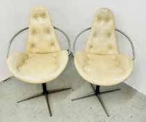 A PAIR OF MID CENTURY ATOMIC STYLE CREAM VINYL SWIVEL CHAIRS ON A CHROME METAL BASE.