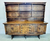 A LARGE CARVED REPRODUCTION OAK WELSH DRESSER WITH DIVIDED UPPER TIER AND RING PULL HANDLES,