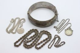 AN ENGRAVED SILVER HINGED BANGLE + TWO SILVER PENDANT NECKLACES,