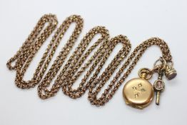A YELLOW METAL GUARD CHAIN WITH LOCKET FOB AND STONE SET WATCH KEY ATTACHED.