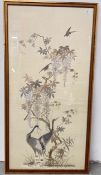 AN ORIENTAL NEEDLEWORK ON SILK DEPICTING CRANES AND A FLOWERING TREE, H 118CM (SOME DAMAGE).