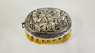 A CONTINENTAL WHITE METAL EMBOSSED DRESSING TABLE BRUSH.