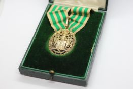 A VINTAGE SILVER GILT MEDAL & RELATED RIBBON TITLED 