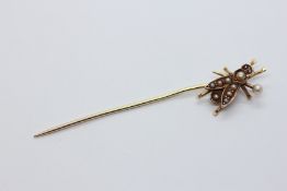 A 14CT GOLD STICK PIN OF FLY DESIGN SET WITH SEED PEARLS.