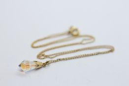 A 9CT GOLD CRYSTAL DROP PENDANT SUSPENDED ON A FINE 9CT GOLD CHAIN, L 42CM.