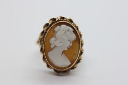 AN ORNATE YELLOW METAL CAMEO RING.