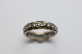 A 9CT GOLD ETERNITY RING (RUBBED).